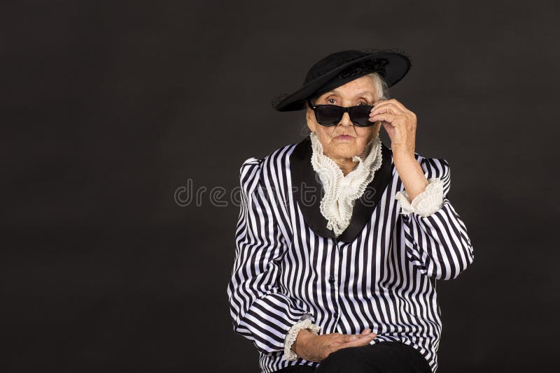 Παλαιό grandma σε ένα άσπρος-μαύρο ριγωτό σακάκι στοκ εικόνα
